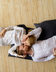 Loving young couple lying and kissing on the floor