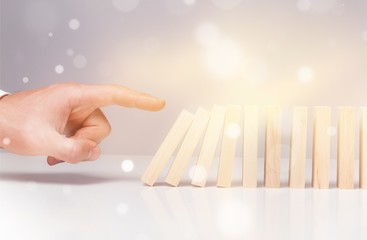 Male hand ready to push domino