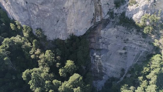 Aerial top view of mountain peaks and green forest. Shot. Beautiful landscape of cliffs, hills, and green trees, nature by drone.
