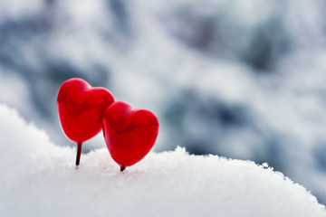 Fototapeta na wymiar Red Valentine lollipops hearts on the white real snow outdoors