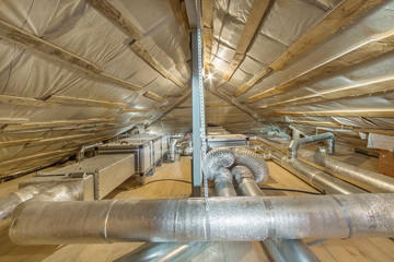 Whole house air ventilation and cleaning system. Ventilation pipes in silver insulation material on...