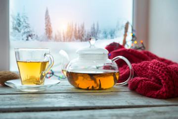 Cup of coffee or tea, smartphone and earbuds with autumn leaves near a window. Autumn playlist...