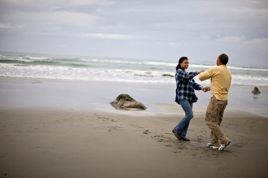 Mature man and woman dancing on the beach
