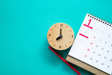 Fototapeta na wymiar close up of calendar, clock and pencil on the table, planning for business meeting or travel planning concept