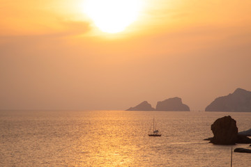 Naklejka na ściany i meble Seascape with boat at sunset in the sea aroudn Ponza island coast. View of the ocean.