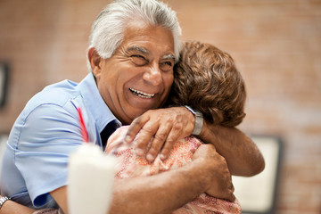 Smiling senior man happily embracing his wife.