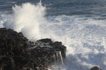 Strong wave of white sea beats on the rocks