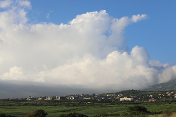 Cloud in the sky hangs over the houses in the mountains.