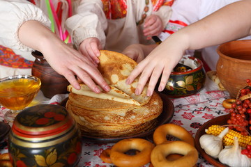 Women's hands take pancakes