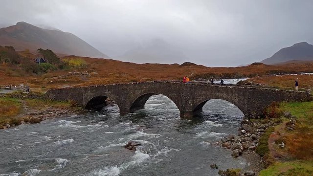 The Sligachan Old stone Bridge over River Sligachan with Beinn Dearg Mhor and Marsco peak of Red Cuillin mountains in autumn Isle of Skye Scotland UK