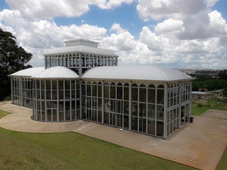 Fototapeta na wymiar Sorocaba, Brazil - January 3, 2019: The back view of the Crystal Palace inside the city's Botanical Garden. Its metal and glass structure is inspired by Joseph Paxton's original design.
