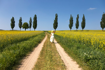 Frau mit Hut und Kleid im Rapsfeld Sommer © Katja Xenikis