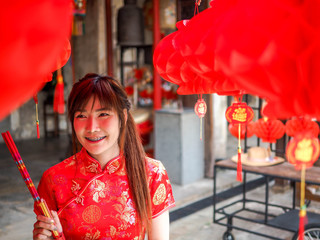Chinese young woman with tradition clothing holding joss sticks (incense), Chinese New Year