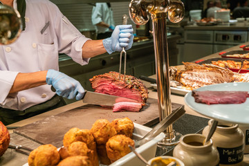 Close up photo of chef slicing and cutting Grilled Beef Steak in the buffet restaurant