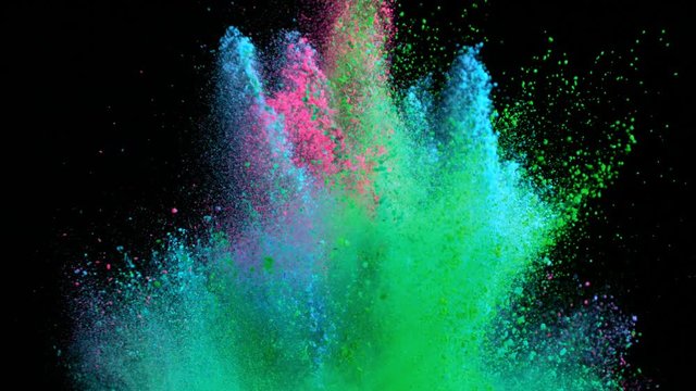 Super slowmotion shot of color powder explosions isolated on black background.