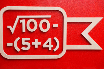 Close-up white wooden simple mathematical equation at red wall at background. Concept of study,...