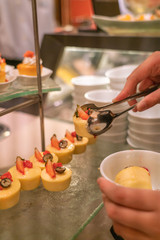 Human hand choosing Cheese cake in the buffet