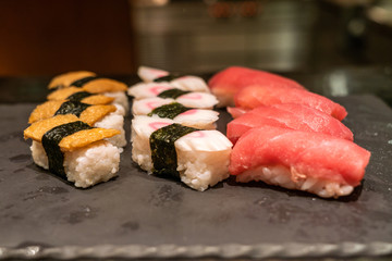 Nigiri sushi set on the black stone slate, flat lay
