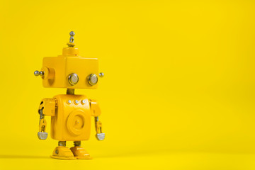 Robot on a yellow background. - obrazy, fototapety, plakaty