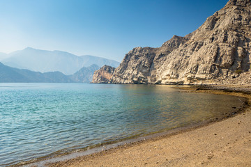 Fototapeta na wymiar Charming view of the mountains and the sea in the haze near the Musandam
