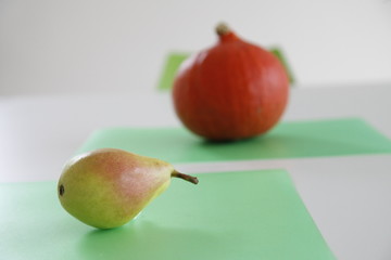 pumpkin and pear on a green background