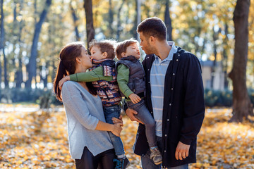 Natural pictures of a happy family of four having fun outsiade on a sunny autumn day. Togetherness and happiness concept