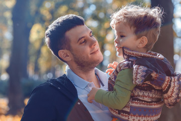 Dad and son playing outside in autumn in the park