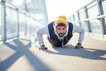 Sportsman doing push-ups at bridge