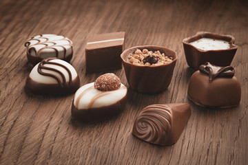 Assortment of chocolates on wooden background