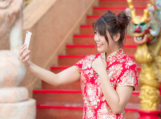 Asian beautiful girl dressed in Chinese national costume is taking pictures