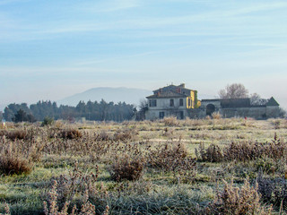 Winter landscape with hoarfrost frozen grass and old typical house in Provence, southern France
