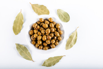 Green olives in bowl with leaves of Daphne on white background, Olives from Antakya, Turkey.