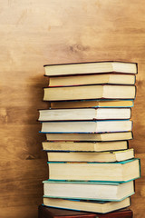 Big pile of books on wooden background.
