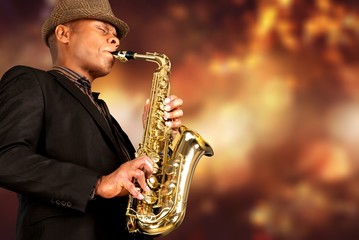 Close-up man playing on saxophone on blurred background