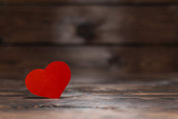 red paper heart on  wooden background. A gift for a loved one on Valentine's day.