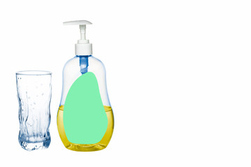 Plastic bottle of detergent stands next to a glass cup on a white background, isolate.