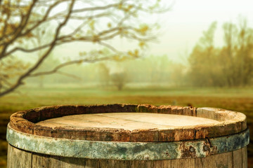 wooden barrel as a table with a free space for an advertising product, the hero on the background of the landscape  