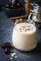 Oatmeal dates cinnamon smoothie on dark background. Selective focus, space for text.