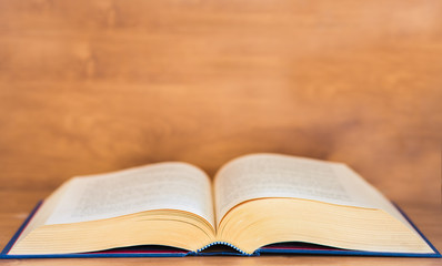 Open book on wooden background.