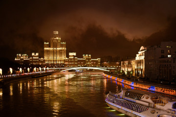 Fototapeta na wymiar Tourist boat on Moscow river, view on Moscow river embankment on Christmas night