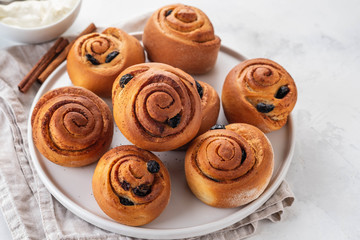 Freshly Baked Traditional Sweet Cinnamon Rolls, Swirl on white plate. Copy space.