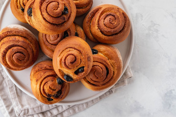 Freshly Baked Traditional Sweet Cinnamon Rolls, Swirl on white plate. Copy space.