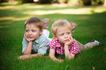 Two young boys walk and relax in the park.