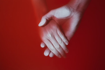 Plexus of the hands of a man and a woman in colored red bloody water, concept of love and loyalty