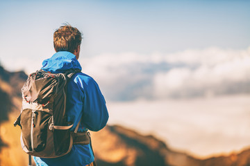 Hiker travel lifestyle young man wearing jacket and backpack on trek trip outdoor in mountains. - obrazy, fototapety, plakaty