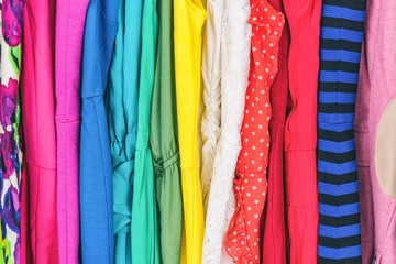 Closet women's fashion outfits clothes arranged in rainbow colors assorted. Clothing store dresses...