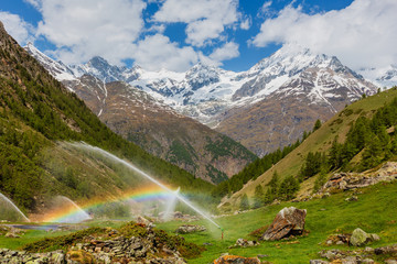 Rainbows in irrigation water spouts in Alps mountain