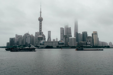 Fototapeta premium Shanghai / China - may 22 2017: Shanghai skyline on a cloudy day with the skyscrapers covered in louds and mist 