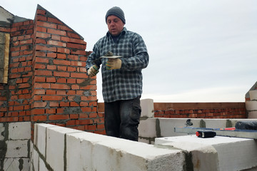 With the help of a glutinous solution, the worker builds a wall of gas blocks