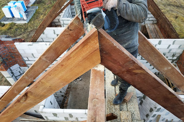 Workers cut the rafters on the roof of the chainsaw house